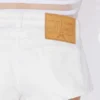 Los pantalones cortos de mezclilla blanca con botones Los pantalones cortos de mezclilla blanca con botones